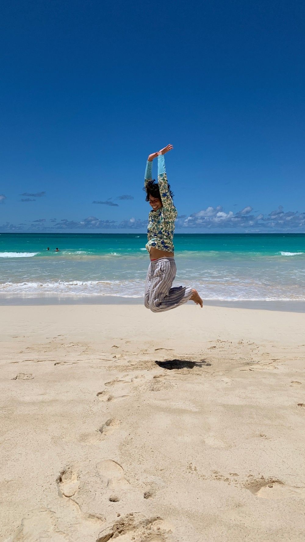 A woman is jumping on a beach