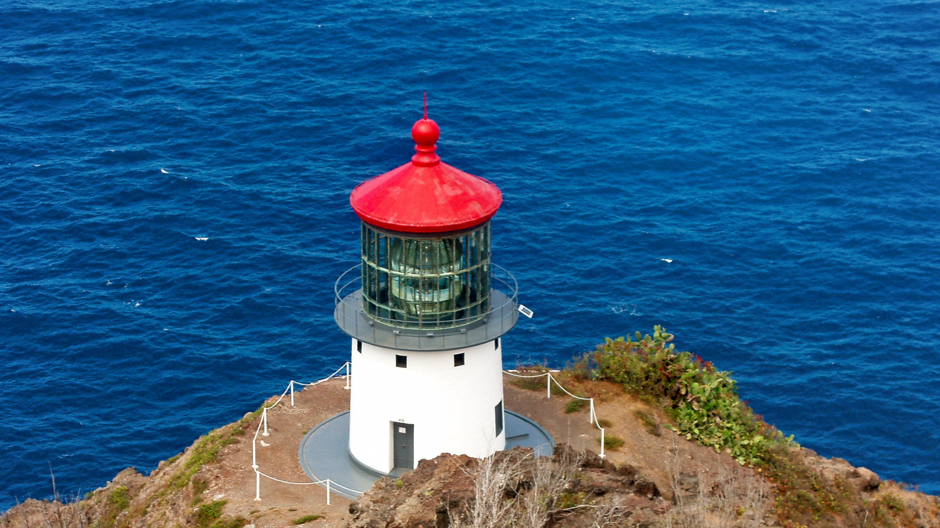 A lighthouse on top of a cliff overlooking the ocean.