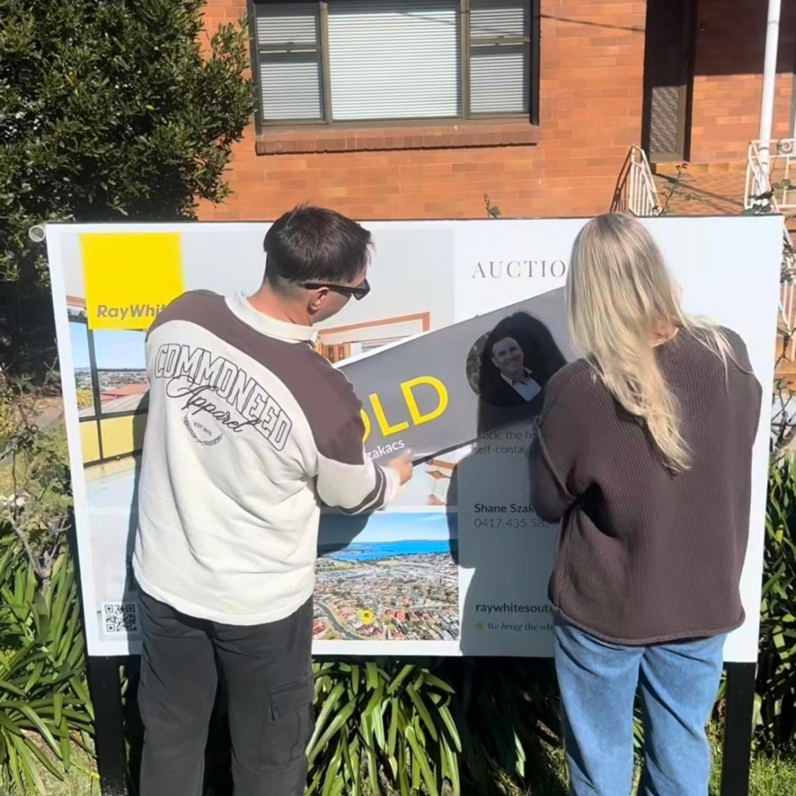 Two people putting up a