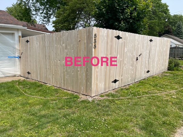 A before picture of a wooden fence in a yard.