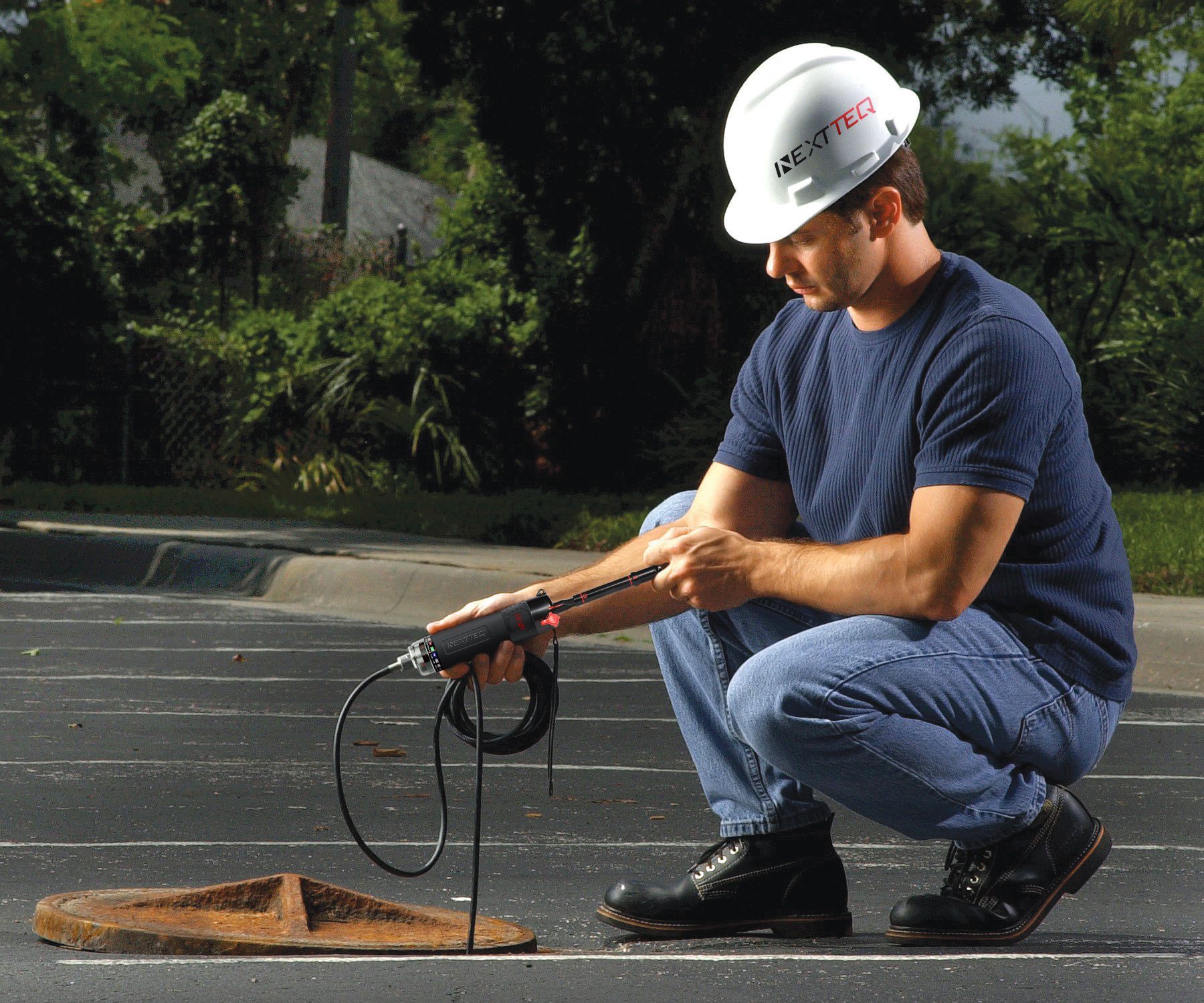 A man taking a sample inside a manhole using the Nextteq® NX-1000 Pump and a Nextteq® Extension Hose.