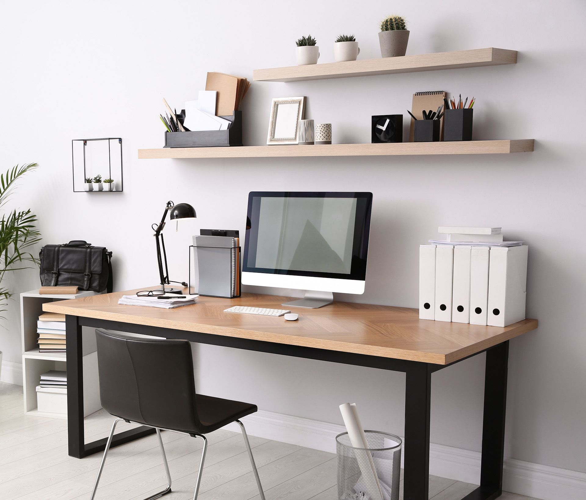 A desk with a computer on it in a room