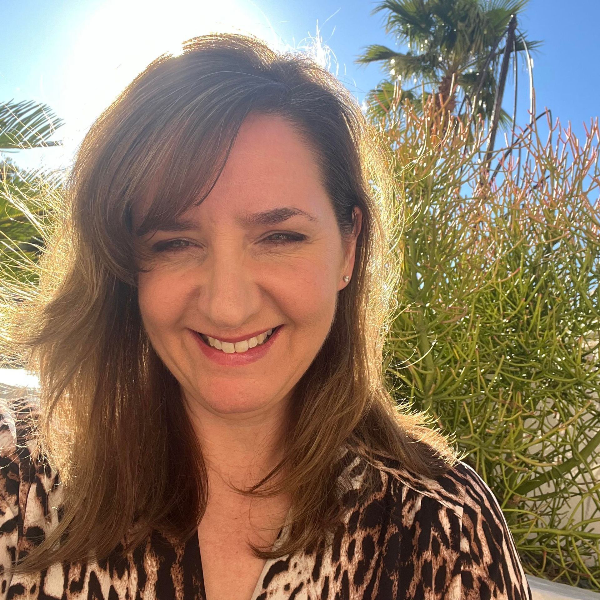 A man is holding a dog in his arms and the dog is wearing a sweater.