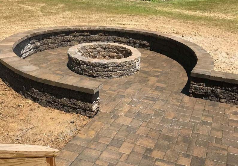 There is a fire pit in the middle of a brick patio.