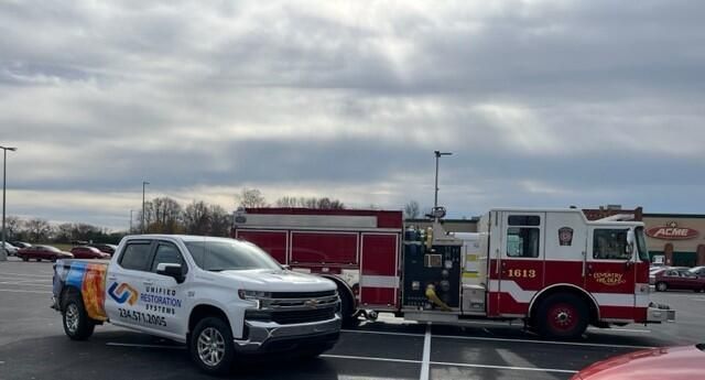Unified Restoration Systems truck parked next to an Akron Firetruck at an Acme parking lot.  URS helps home and businesses mitigate and restore damages from fire, flood, storms, and mold!  (234) 571-2005