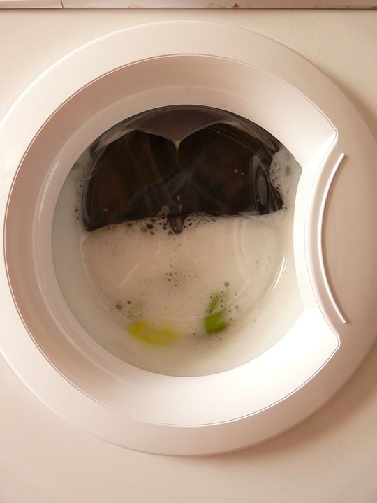Washing machine with dirty clothes and lots of suds