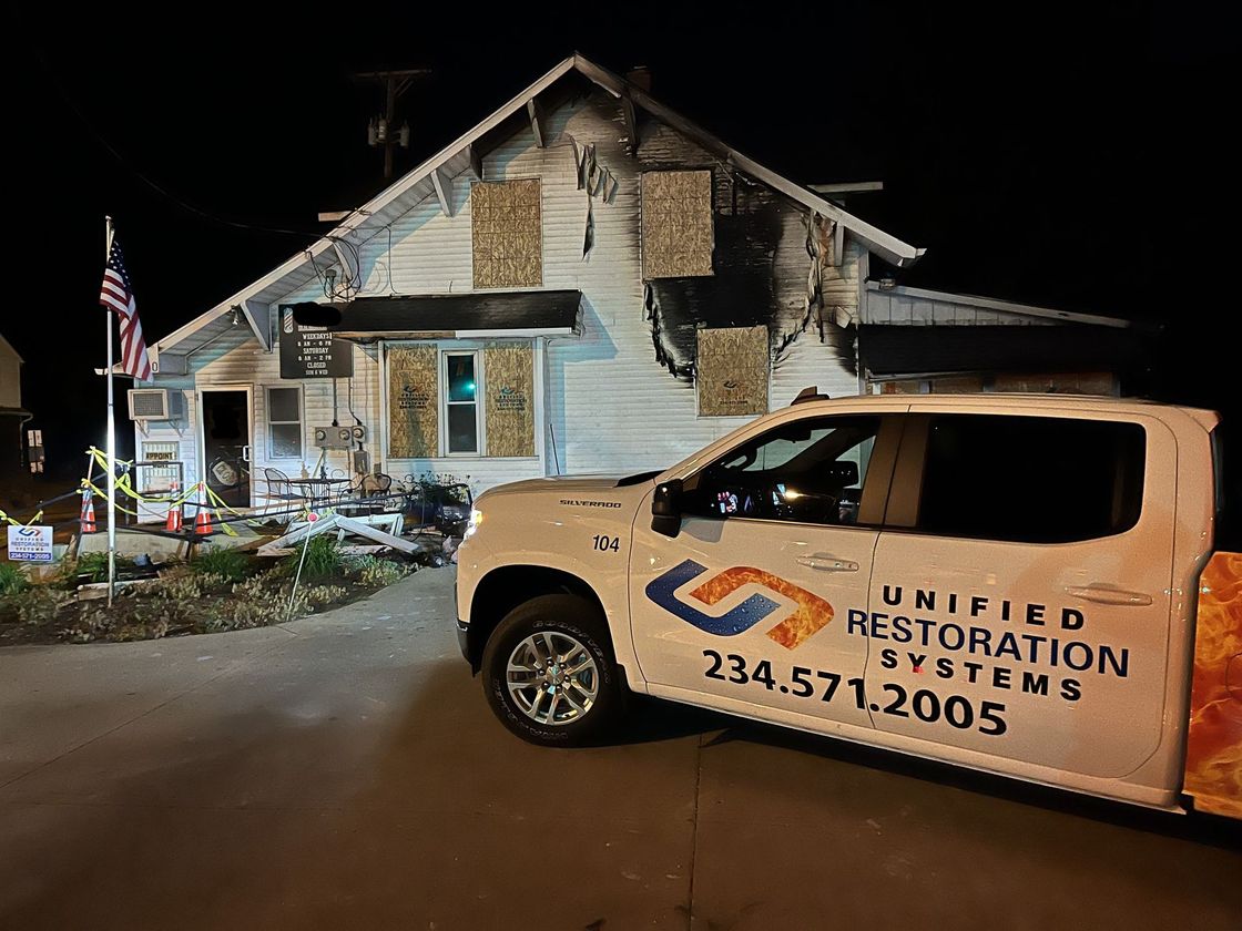 Unified Restoration Systems fire damage truck on site of a business fire at a barber shop