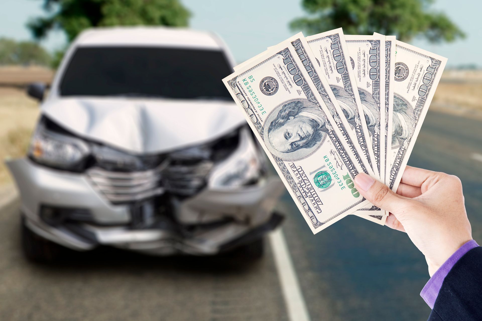 Hands of a businessman holding currency dollars from a junk car buyer on the highway. Hands of a businessman holding currency dollars from a junk car buyer on the highway.