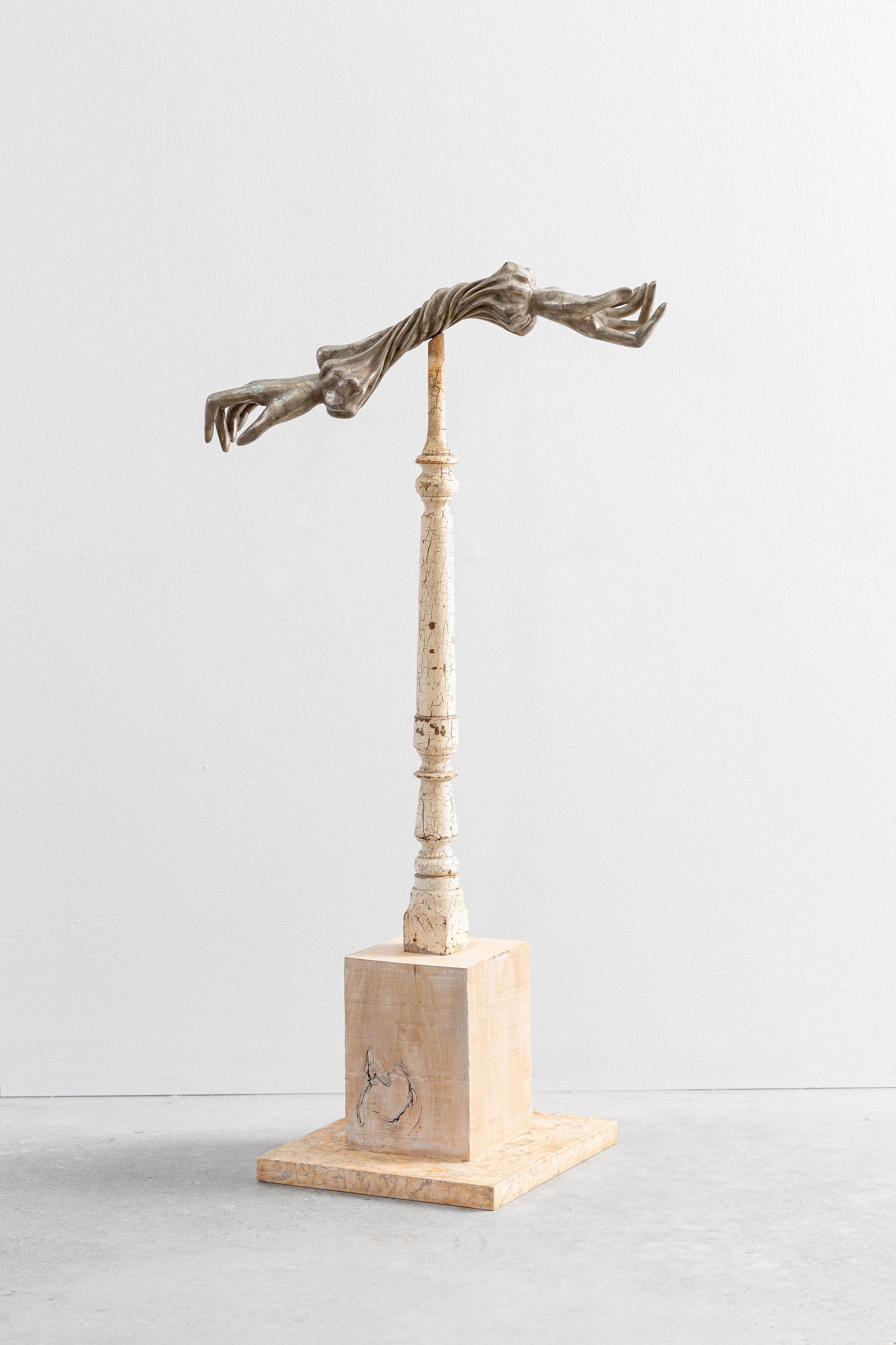 Sculptural wooden figure on a square base against a plain light background
