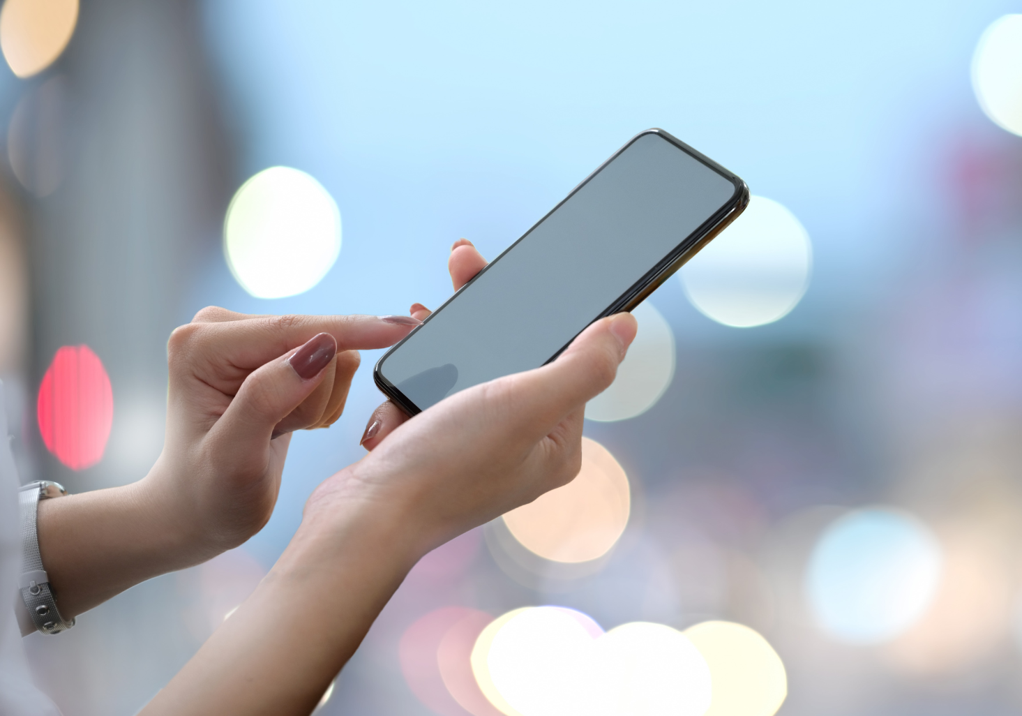 A woman is holding a cell phone in her hands.