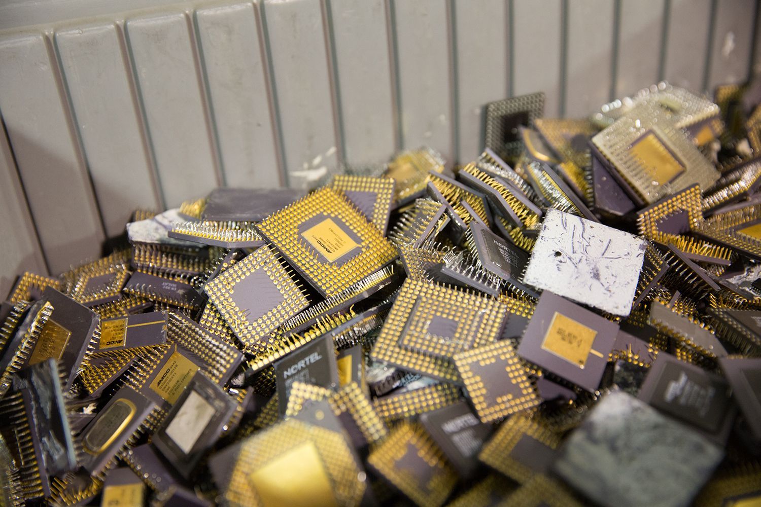 A pile of broken computer chips in a bin