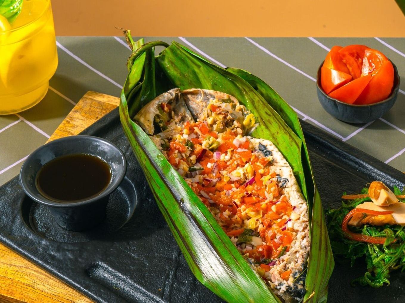 Bangus wrapped in a banana leaf on a table by Top restaurants in Palawan