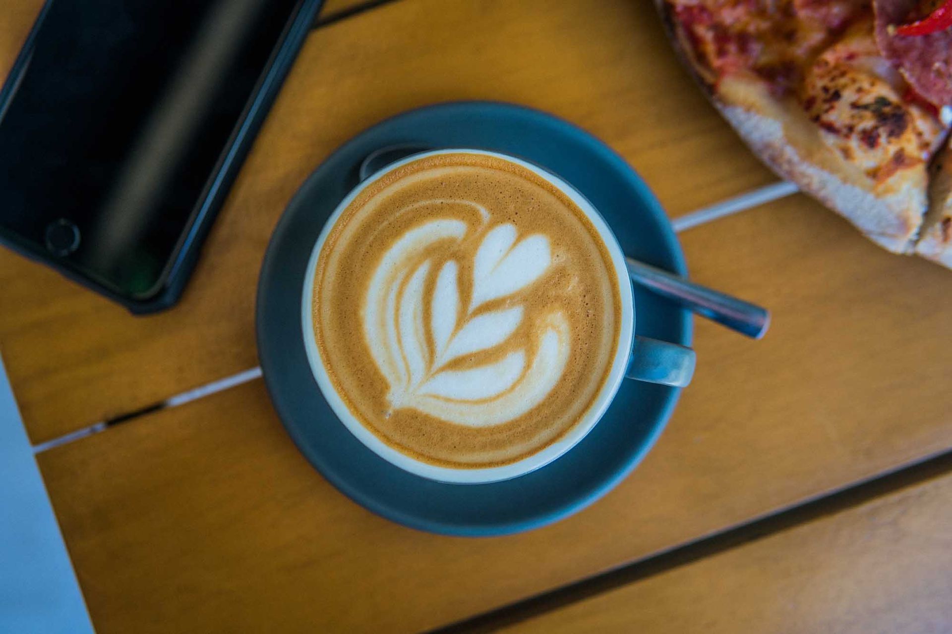 A cup of cappuccino on a saucer on a wooden table of a restaurant in Boracay station 2