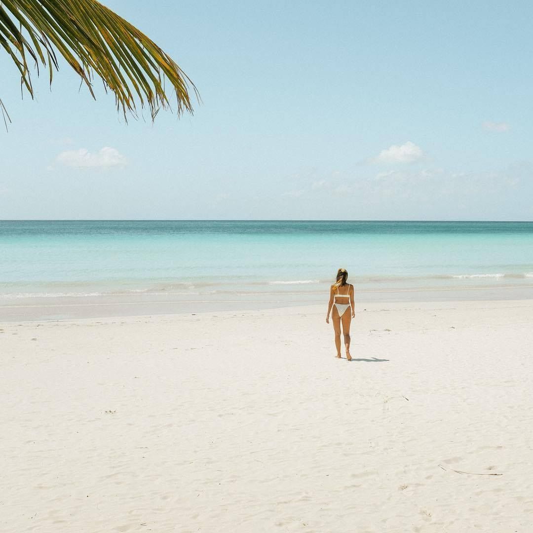 A woman in a bikini is walking on a beach in palawan