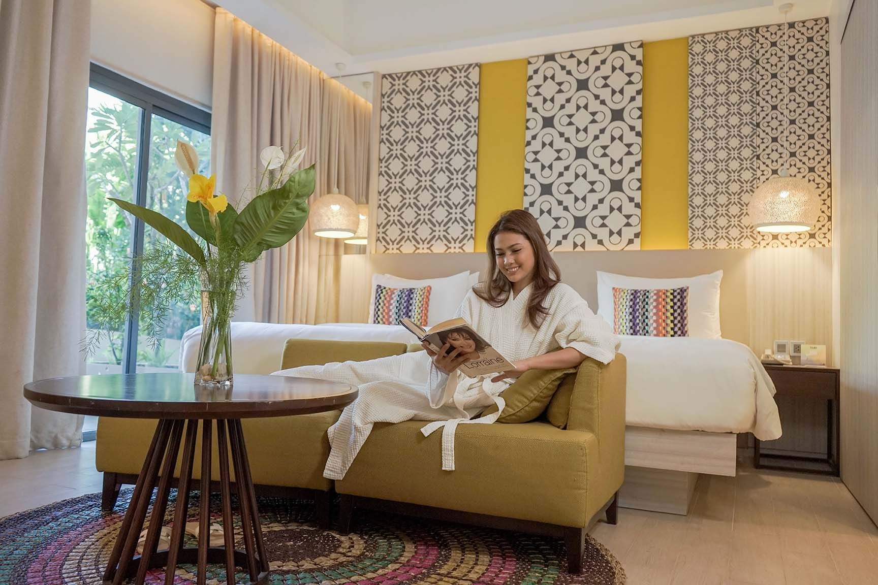 Guest relaxing in a bright, modern suite living area at Hue Hotels in Puerto Princesa, Palawan