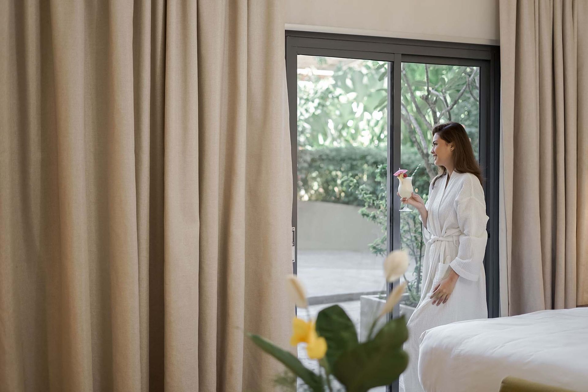 A woman in a bathrobe is standing in a hotel room in puerto princesa 