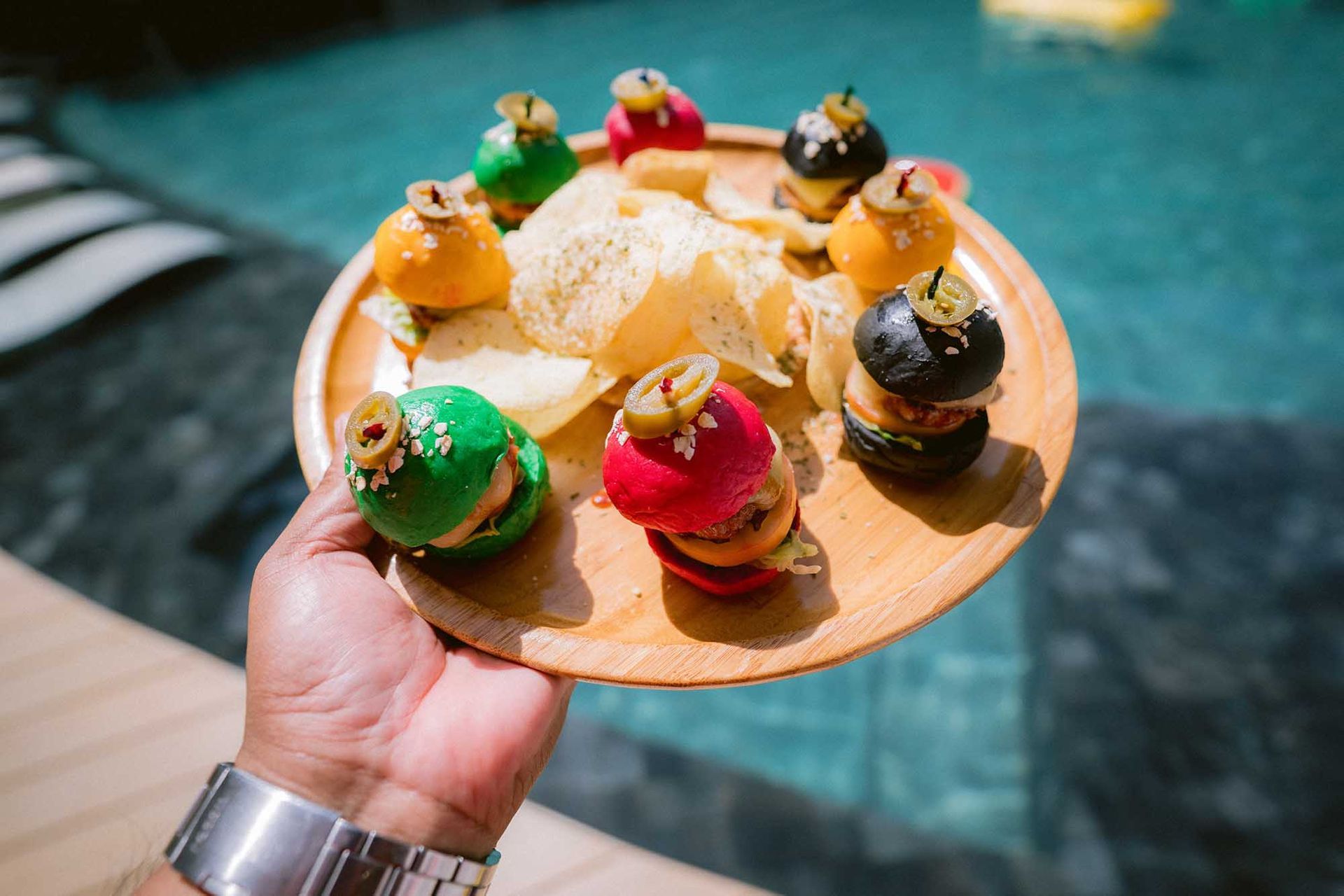 A person is holding a plate of food next to a pool in Boracay restaurants