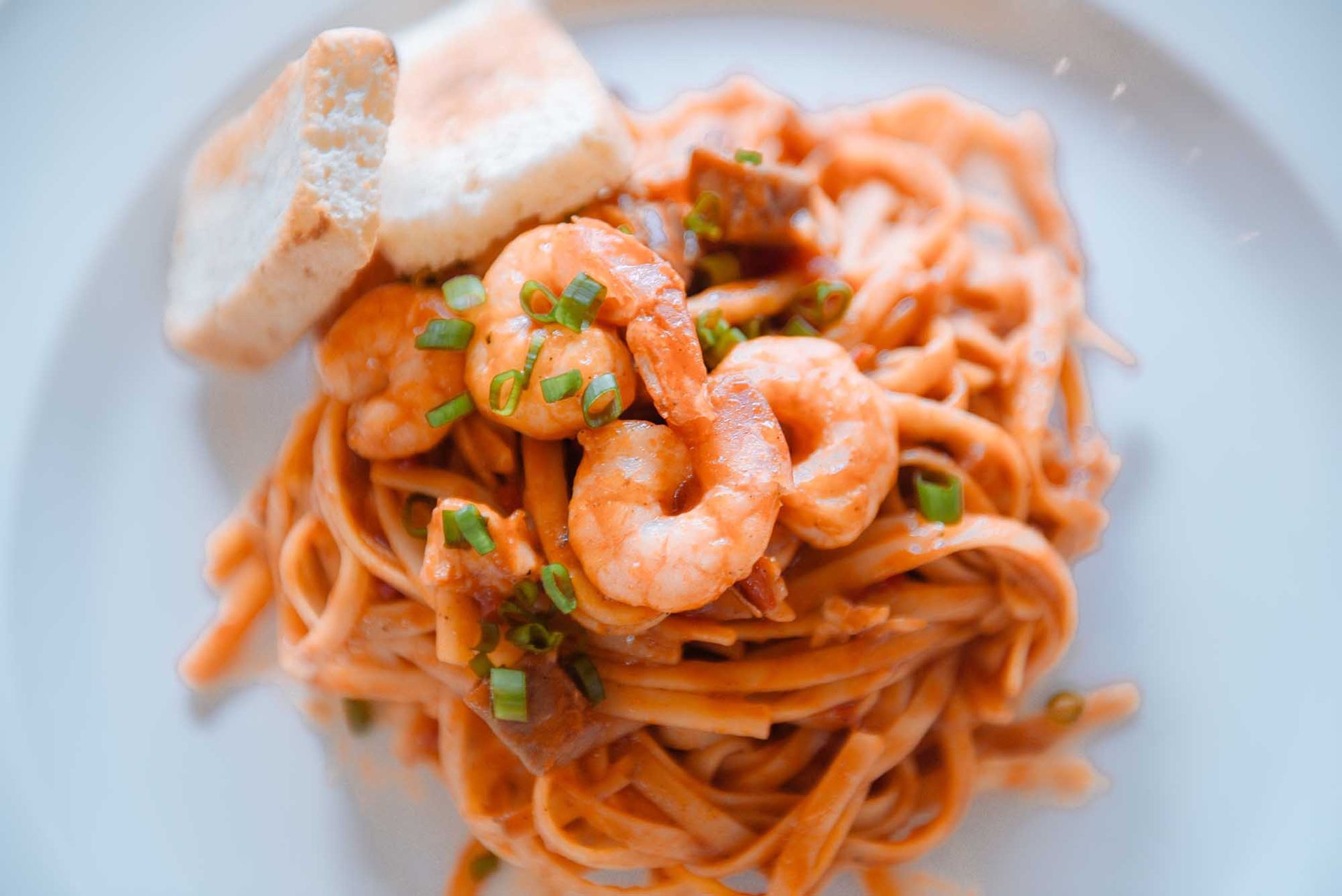 A close up of a plate of pasta with shrimp and bread from Boracay restaurants
