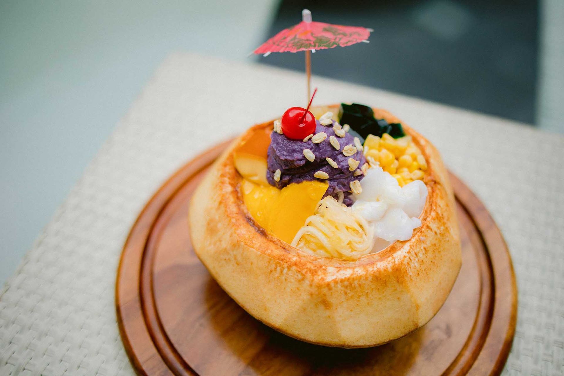 A dessert in a coconut shell with an umbrella on top from top the restaurants in Boracay