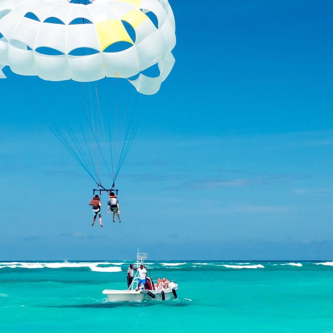 A group of people are parasailing over the ocean of Boracay