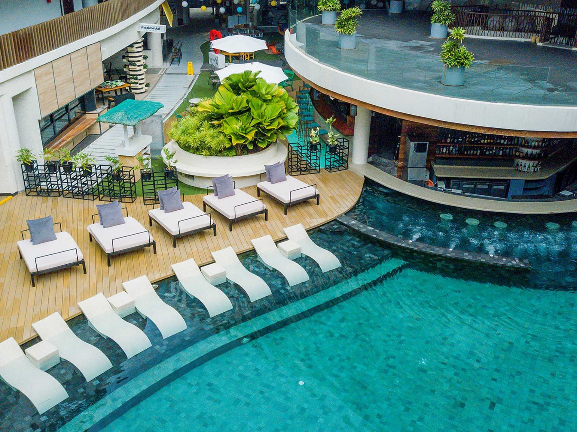 An aerial view of a swimming pool with lounge chairs and umbrellas in Hue hotel