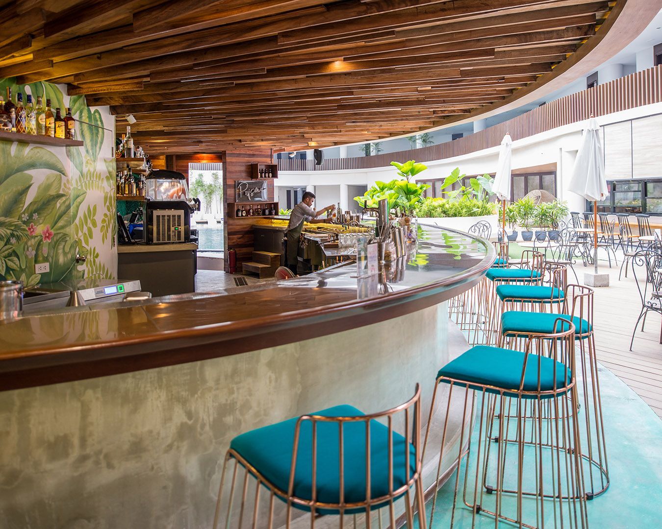 A bar with stools and a wooden ceiling in a restaurant near Hue Boracay for parents.