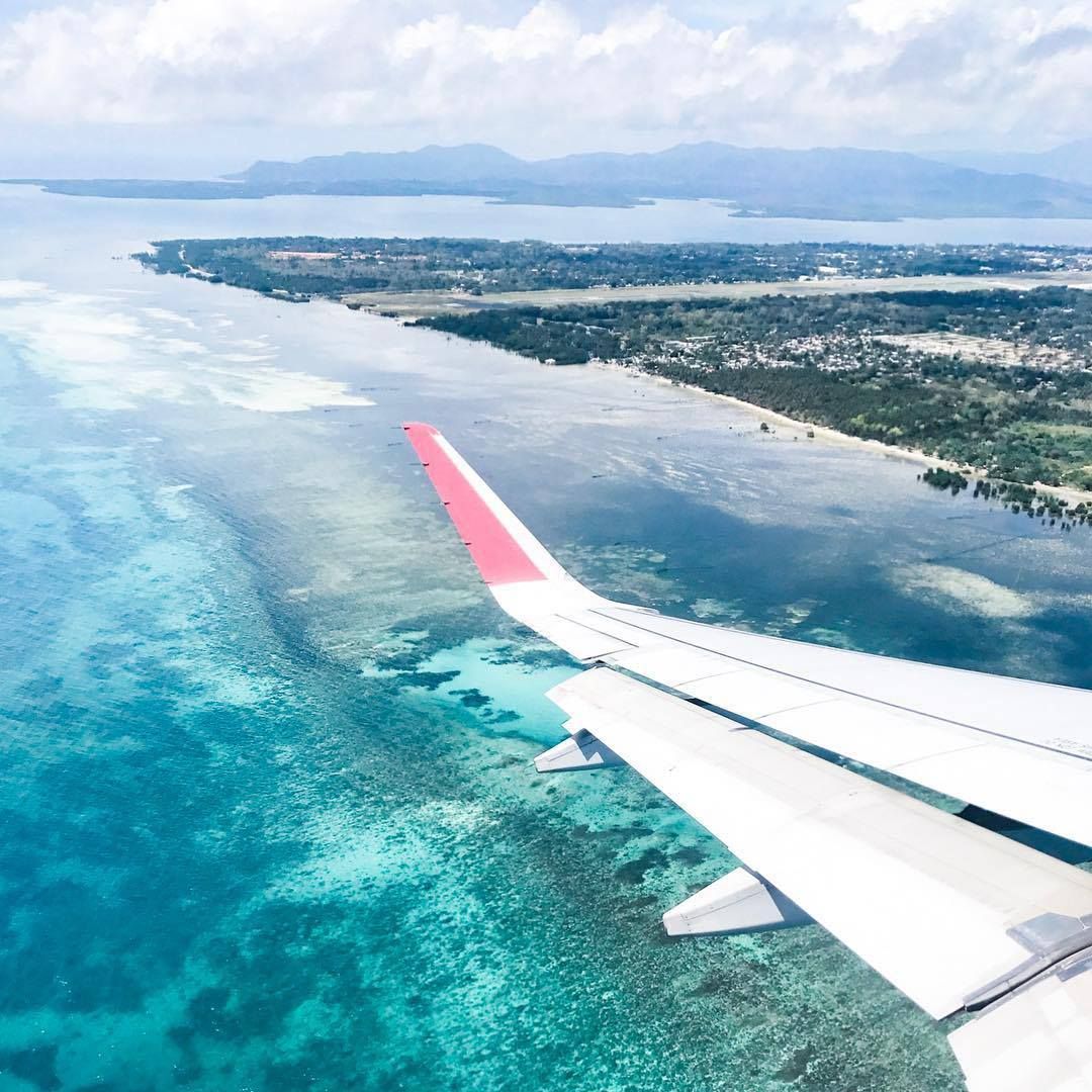 An airplane is flying over the ocean to Puerto Princesa