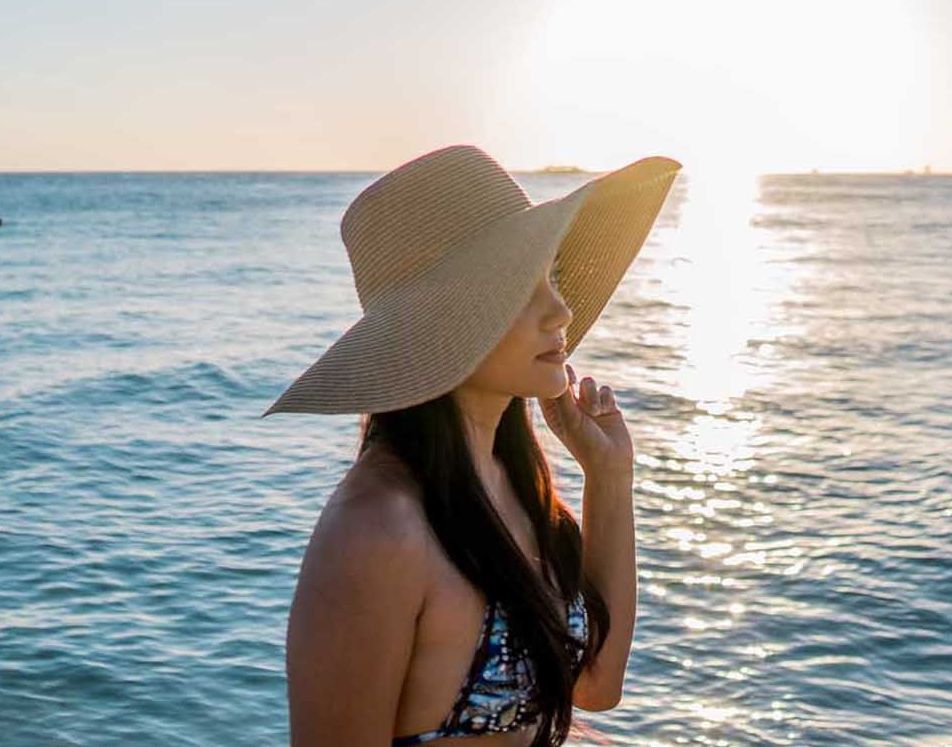 Woman in sunhat watching sunset at Boracay beach, perfect for family vacations in Hue Hotel Boracay