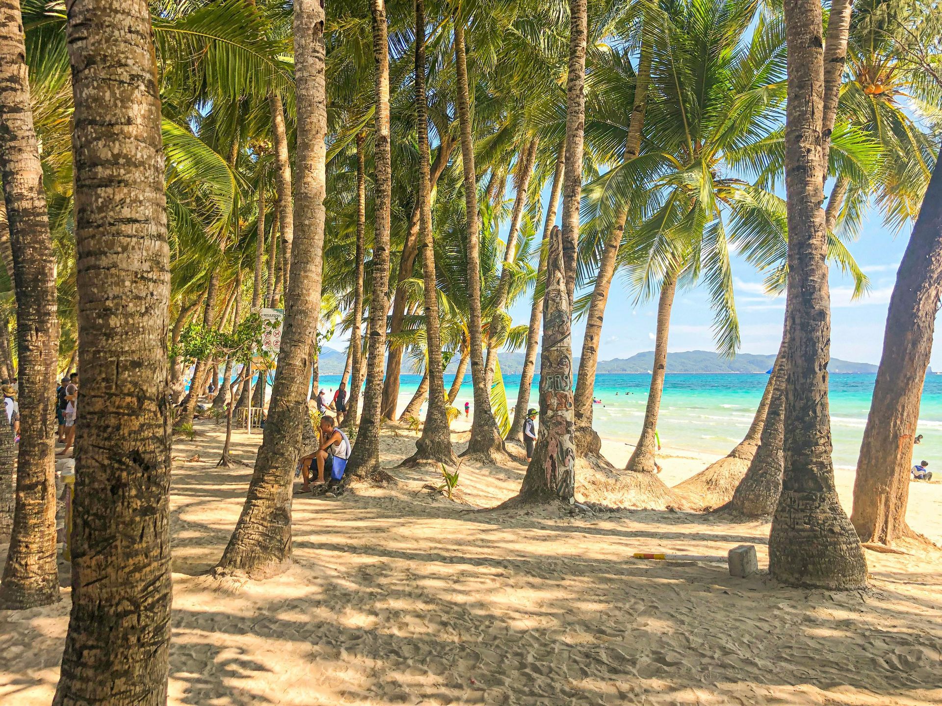 Palm-lined beach pathway near Boracay Station 2, showing direct beach access from beachfront hotels