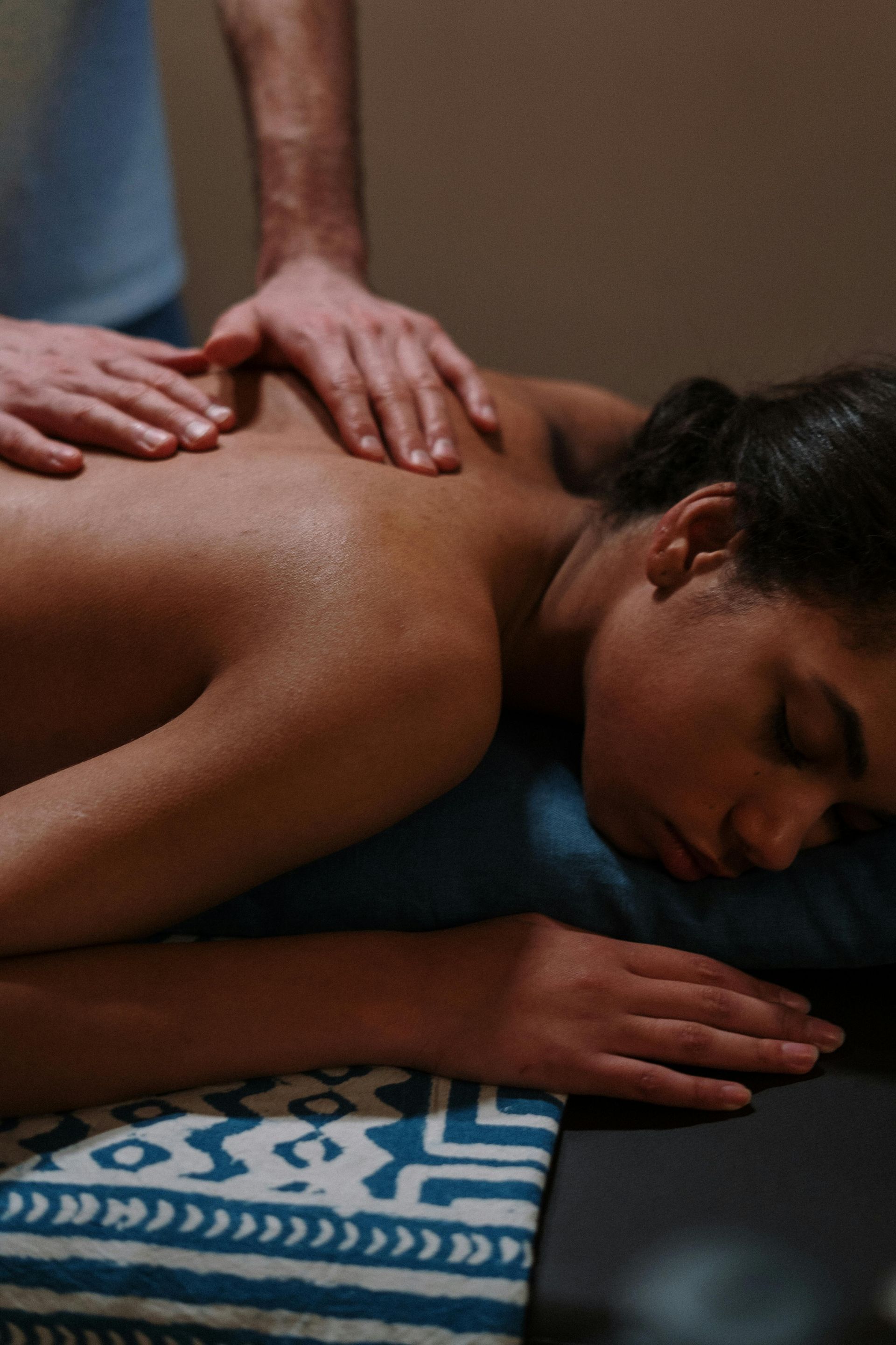 A woman is laying on a table getting a massage at Amirah Spa 