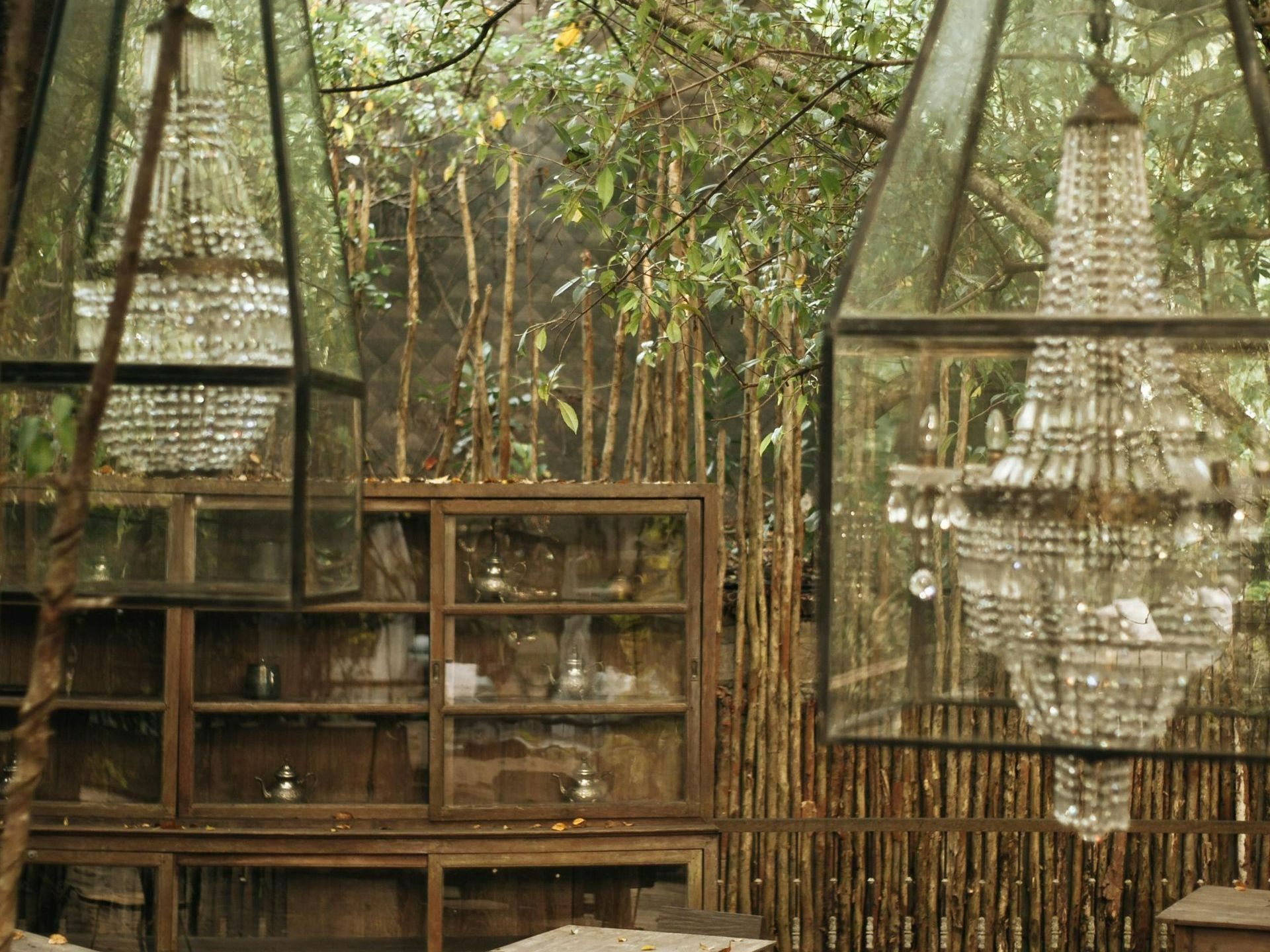 Rustic garden dining area near Hue Hotel - Puerto Princesa featuring crystal chandeliers and bamboo accents