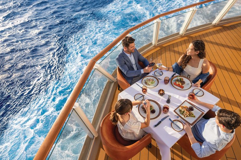 Family dining on a cruise ship deck, enjoying food and the ocean view.