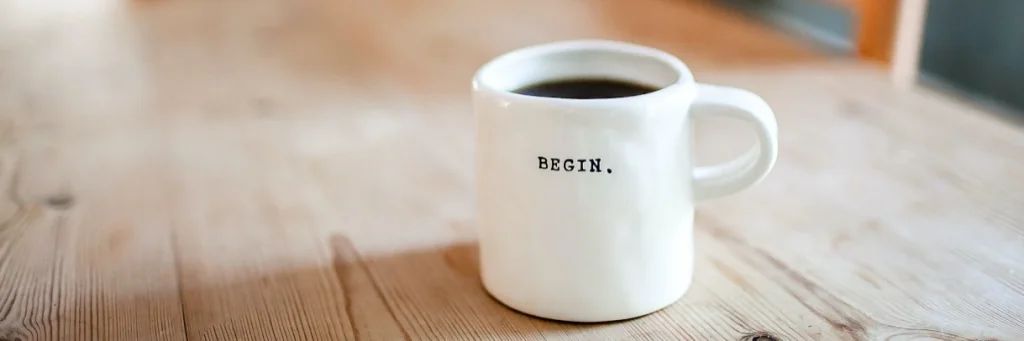 A cup of coffee is sitting on a wooden table.
