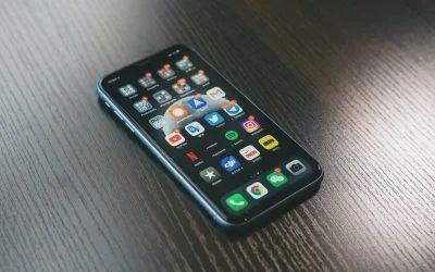 A cell phone is sitting on a wooden table.