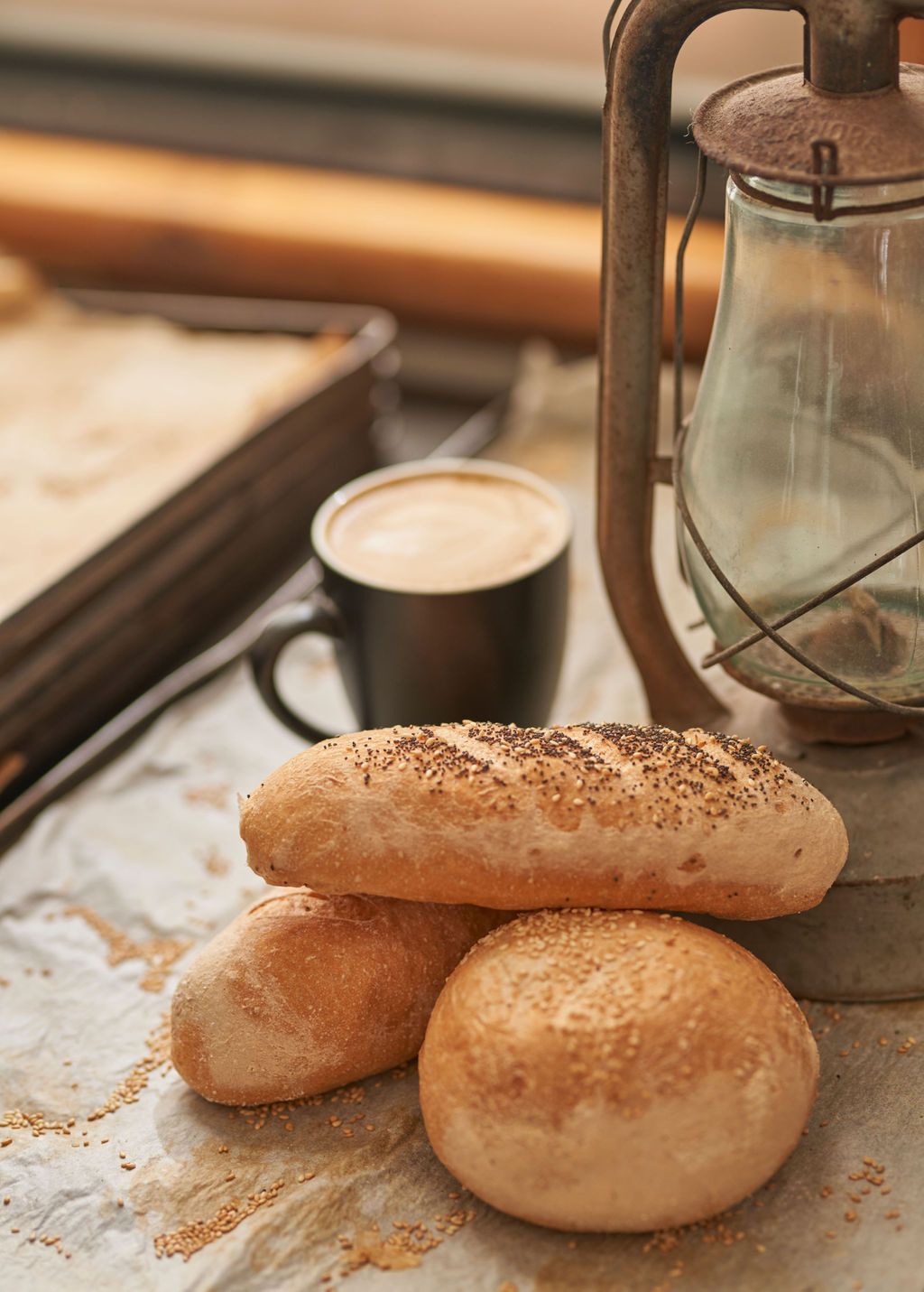 A bunch of rolls and a cup of coffee on a table.
