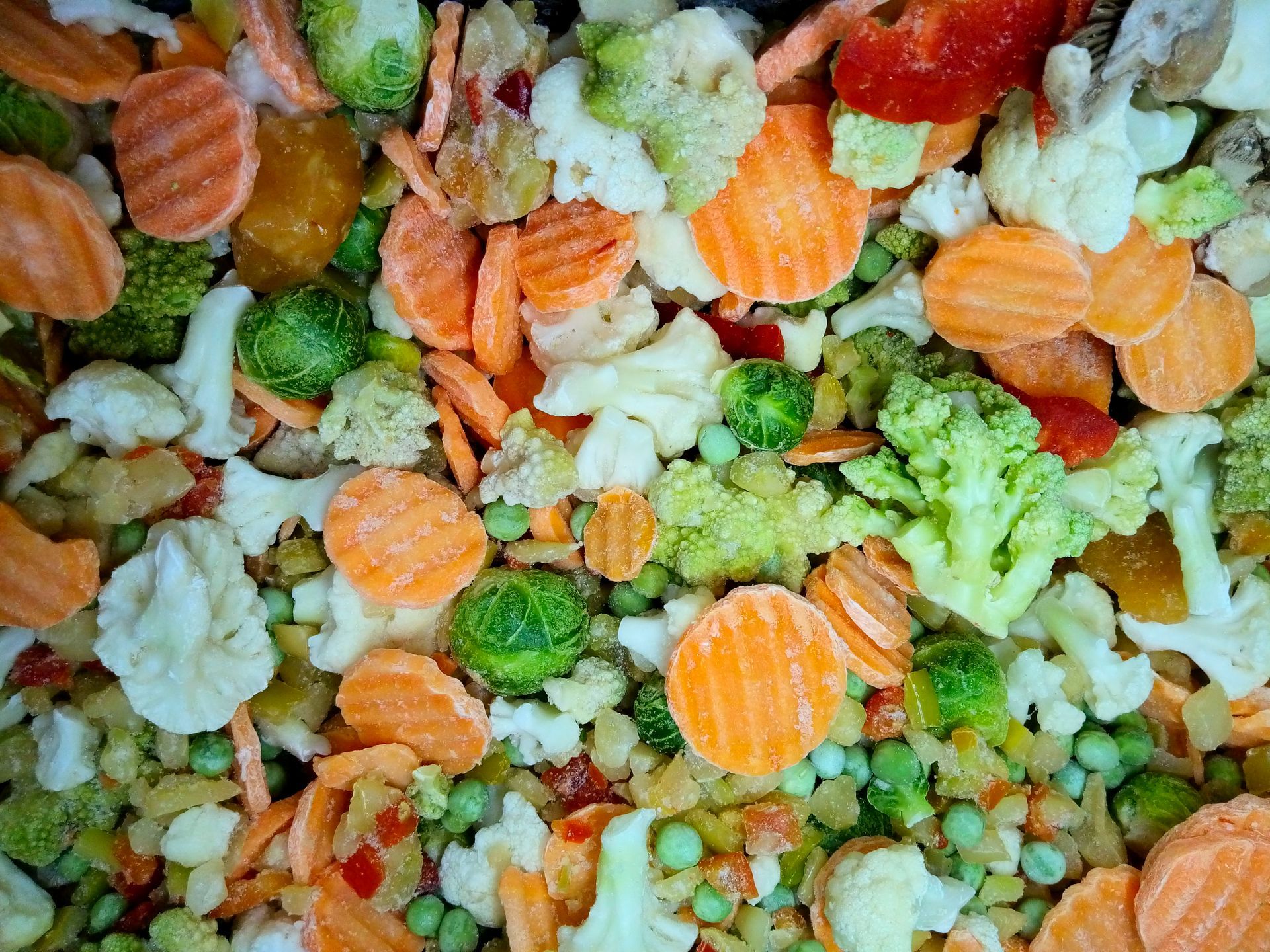 Un primo piano di un mix di verdure surgelate con piselli, mais, carote e cavolfiore.