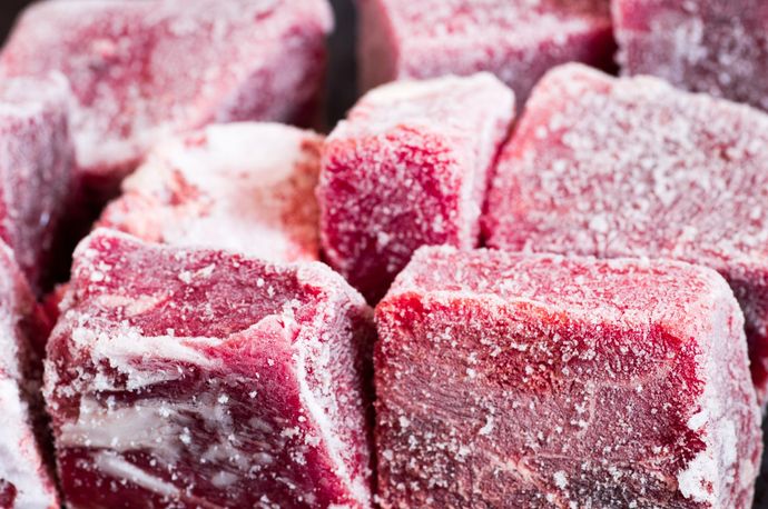 Primo piano di cubetti di bacche rosse ghiacciate ricoperte di cristalli di ghiaccio