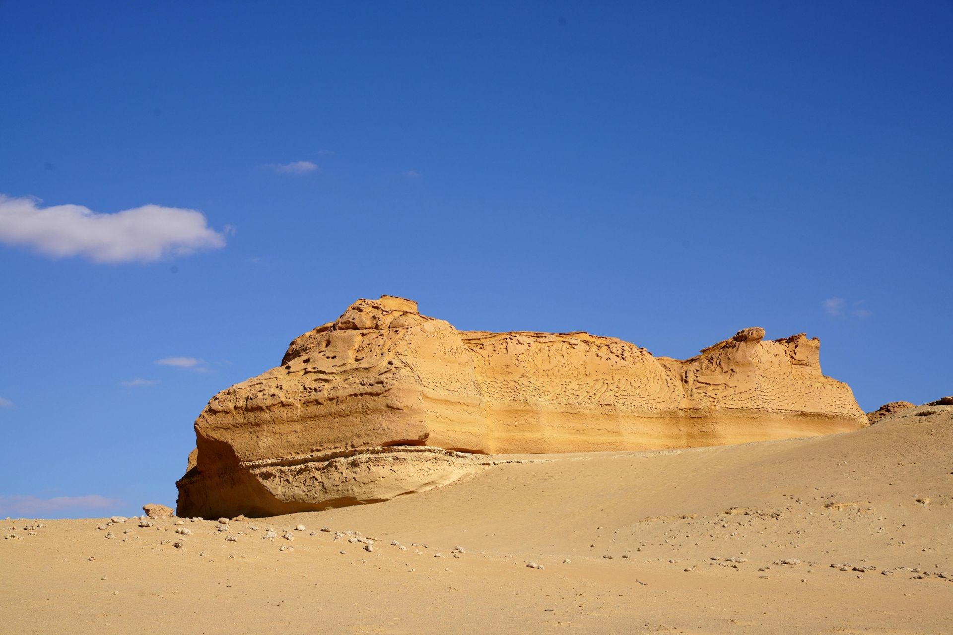 Sandstone formation in desert with blue sky.