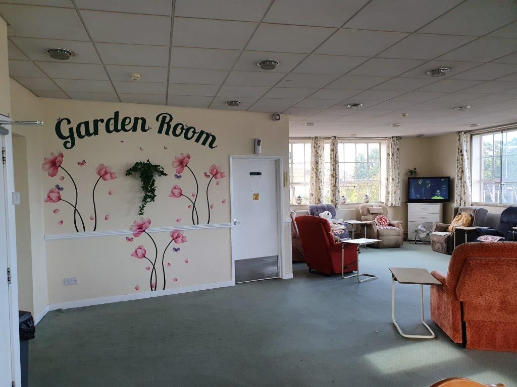 A large room with a garden room written on the wall