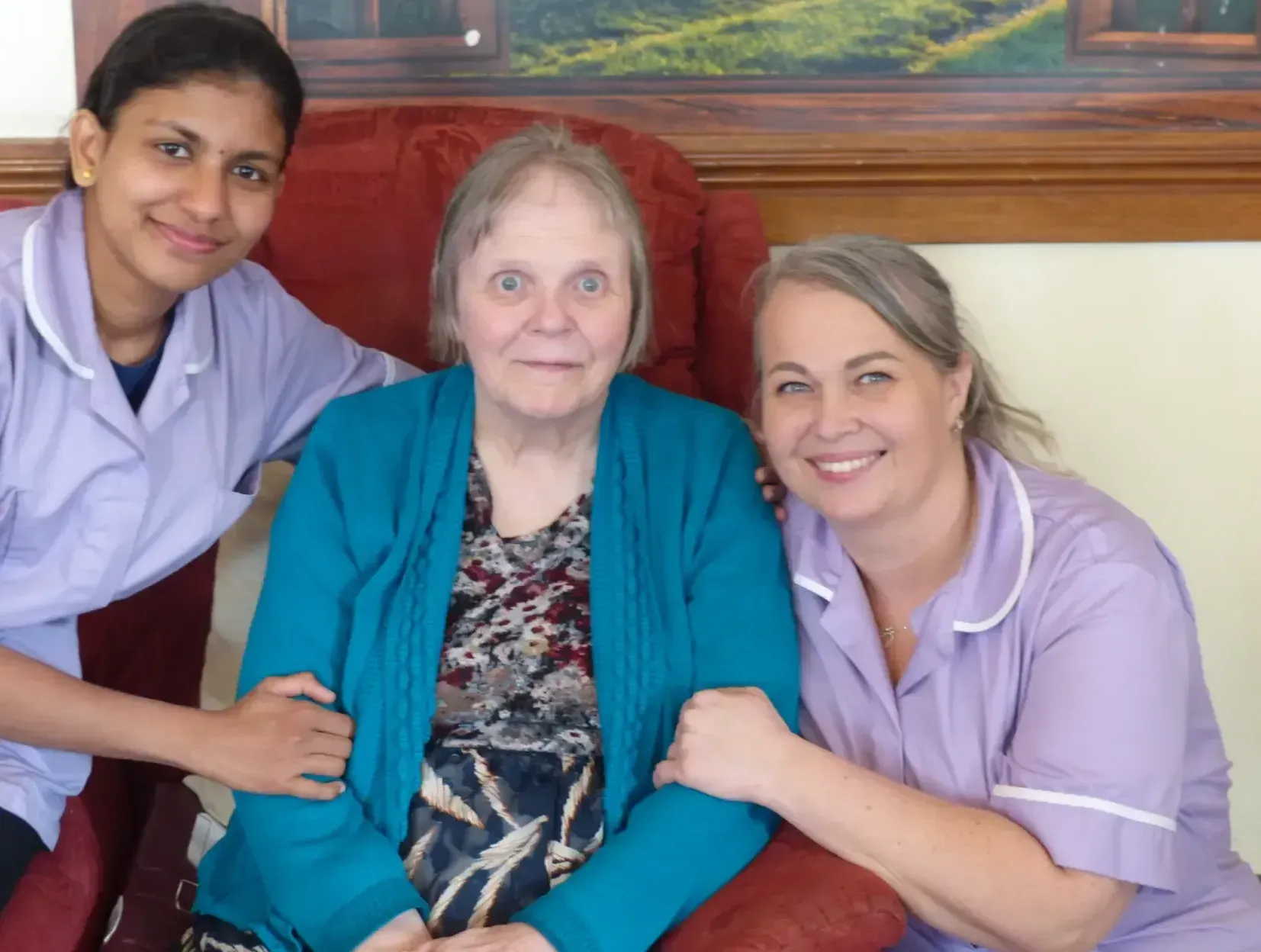 Two nurses are posing for a picture with an elderly woman
