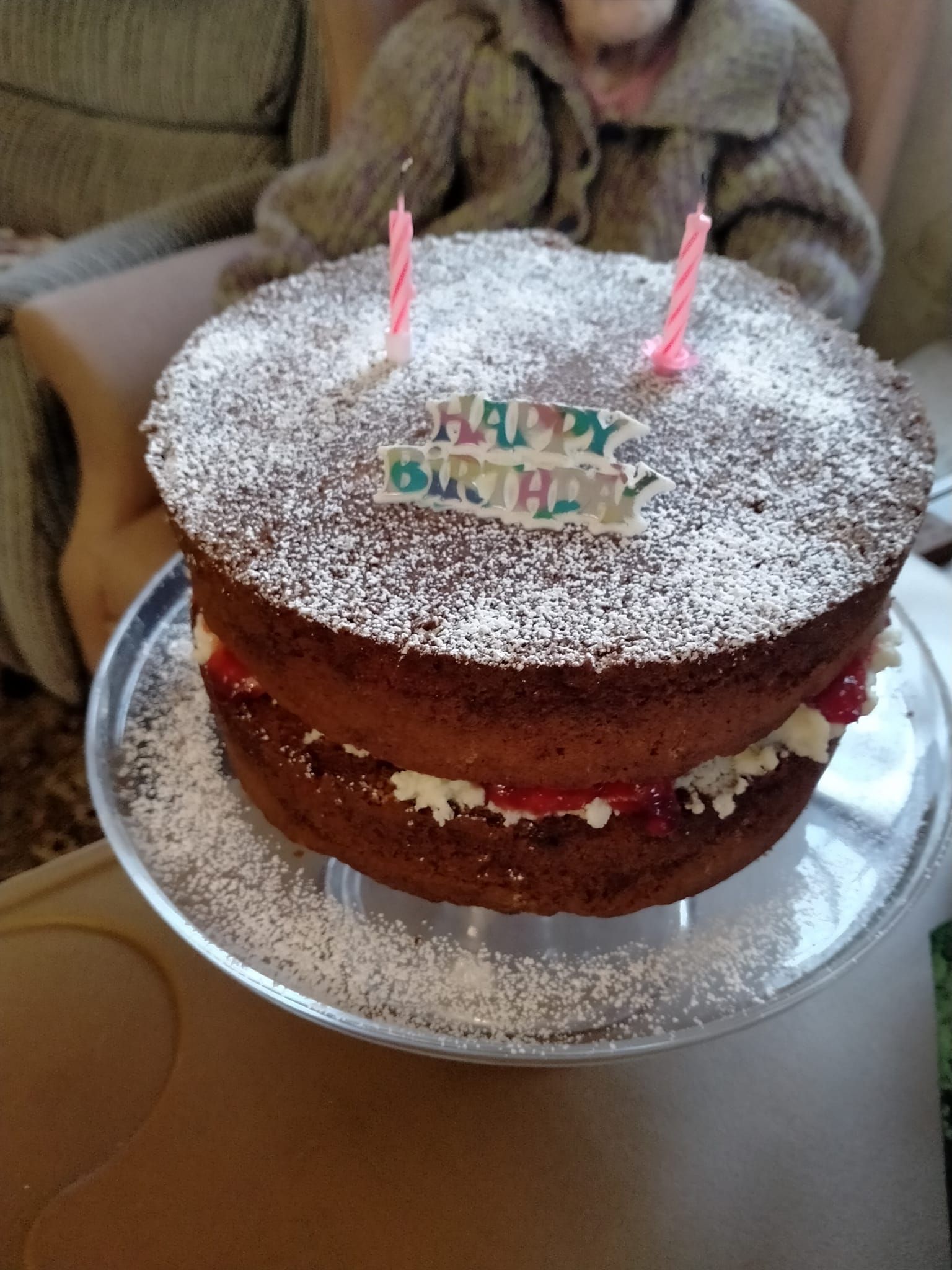 A birthday cake with two pink candles and the words happy birthday on it