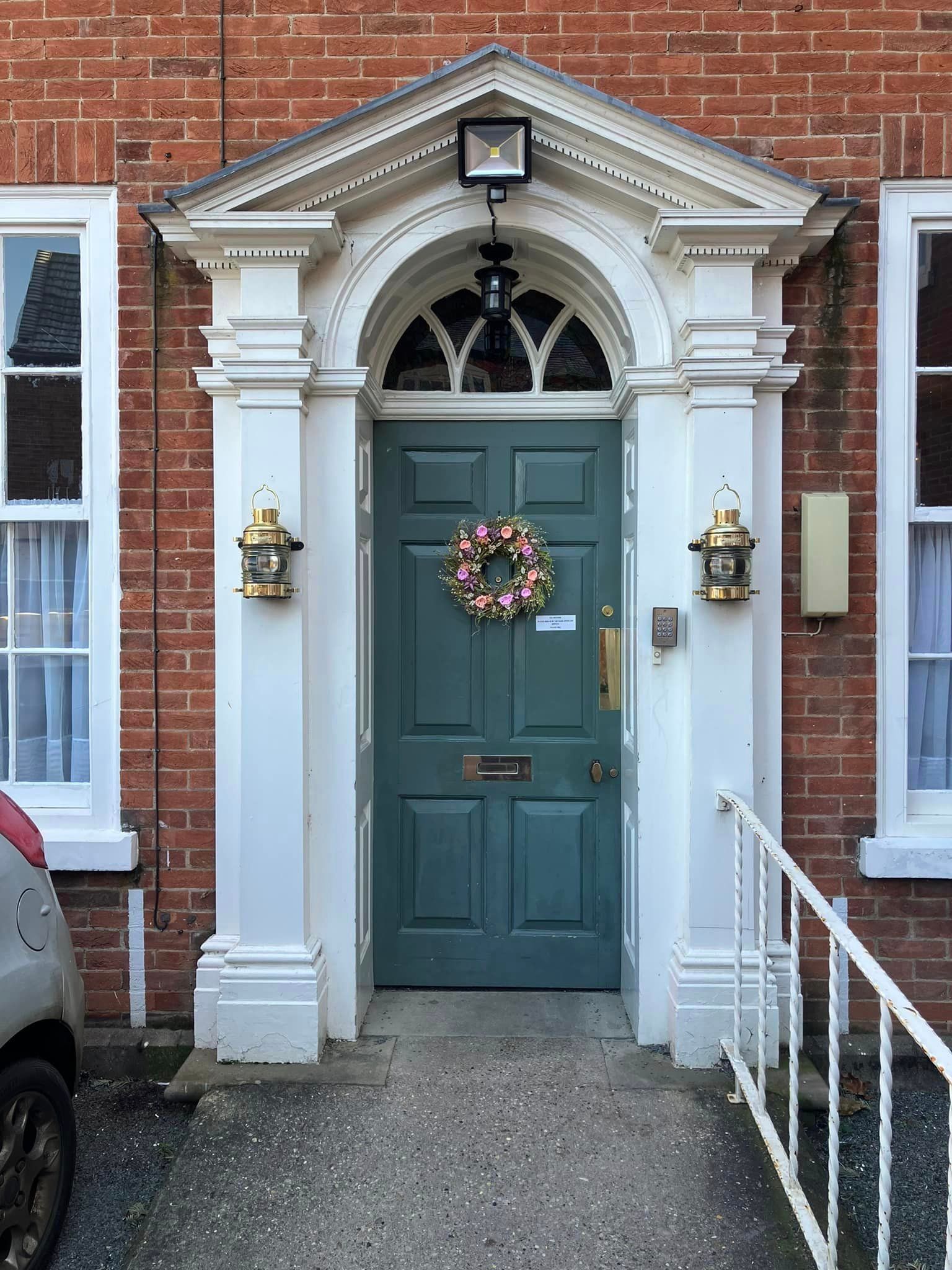 A brick building with a blue door and a wreath on it