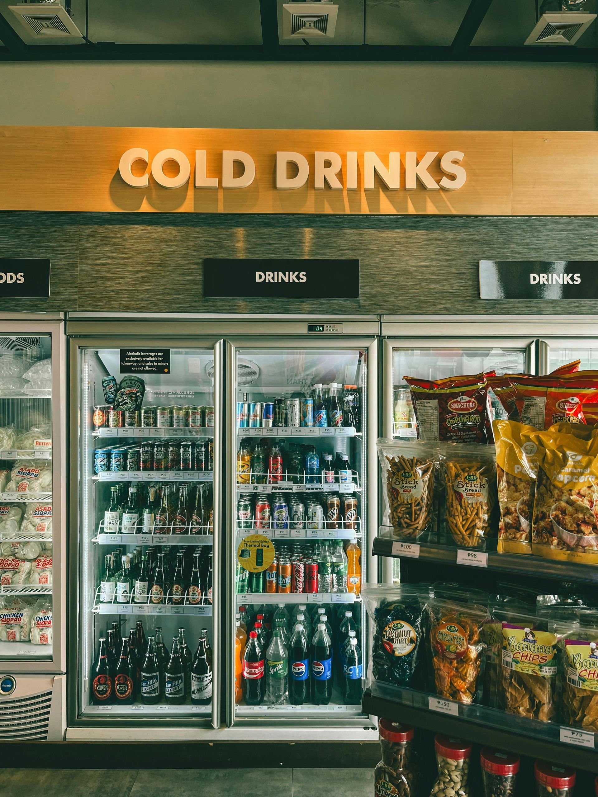 Refrigerated cold drinks display with sign above:
