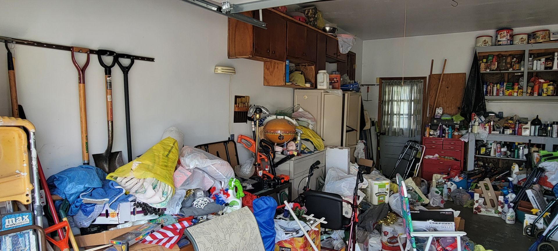 A garage that is packed to the rim with stuff in a house for sale