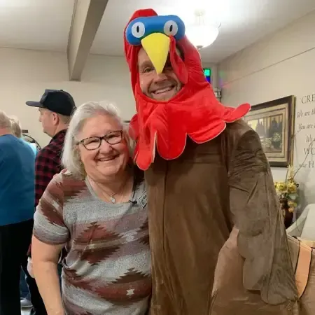 a man in a turkey costume is posing for a picture with a woman .