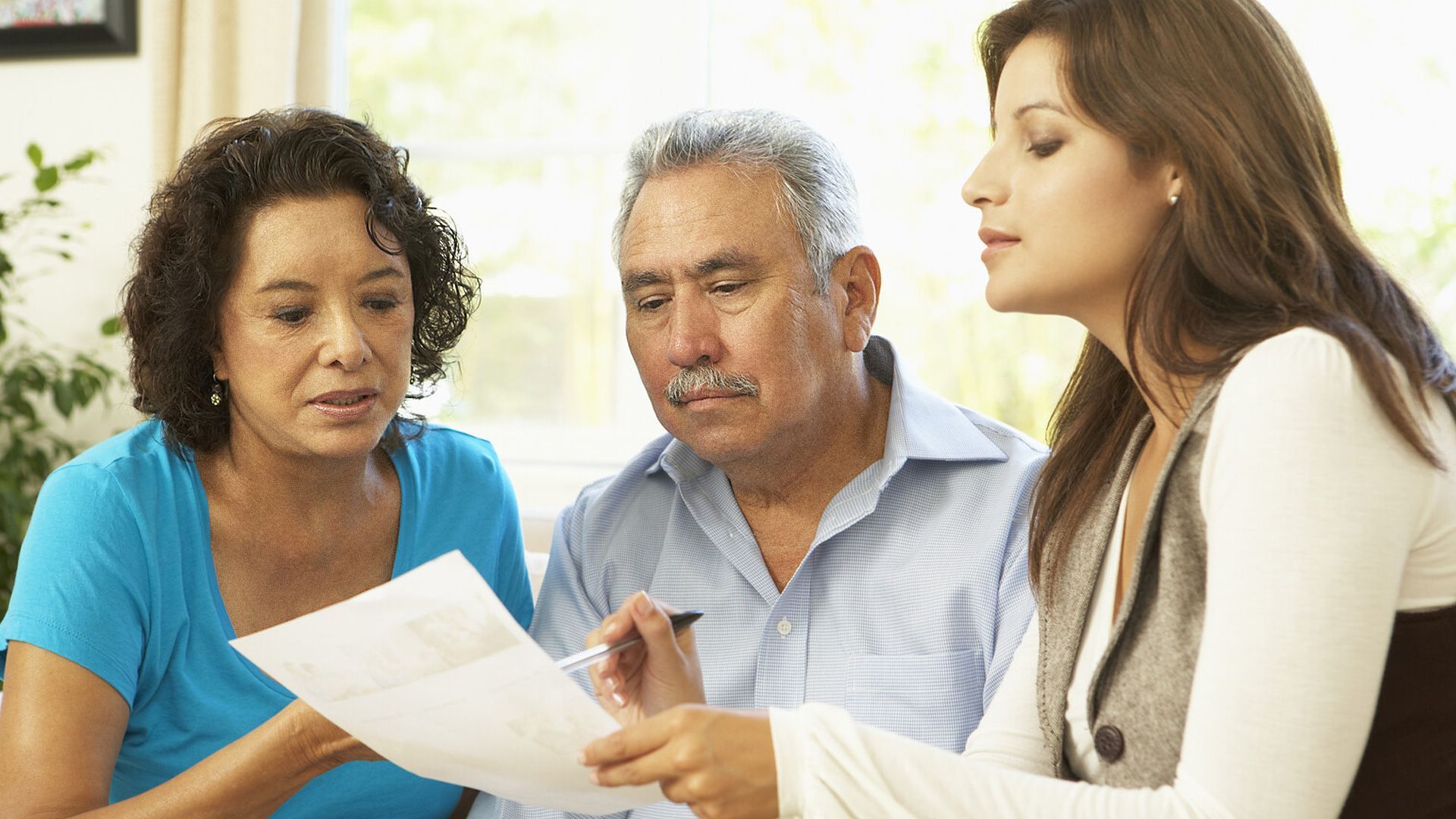 two women reading the definition of activities of daily living to a senior man