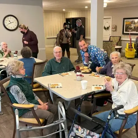 a group of people are sitting at tables in a room .