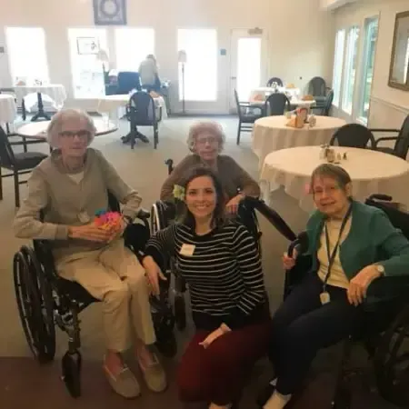 a group of women in wheelchairs are posing for a picture .