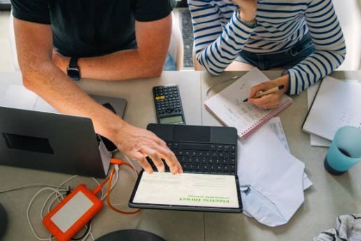 two people looking at a table and finances at the dining room table