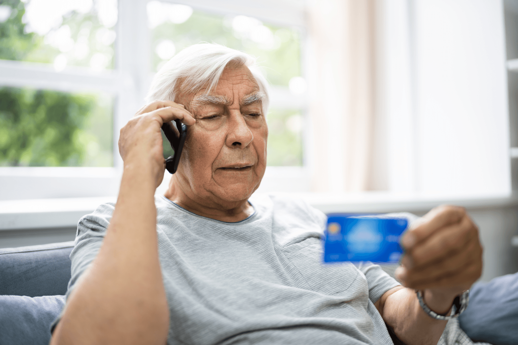 older man reading a credit card over the phone